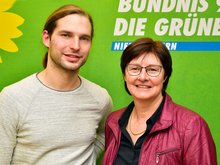 Das Foto zeigt die Landtagsabgeordneten Rosi Steinberger und Toni Schuberl vor einem Banner mit dem Logo von Bündnis 90/Die Grünen.